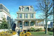 небольшой домик с зелеными ставнями и уютной террасой